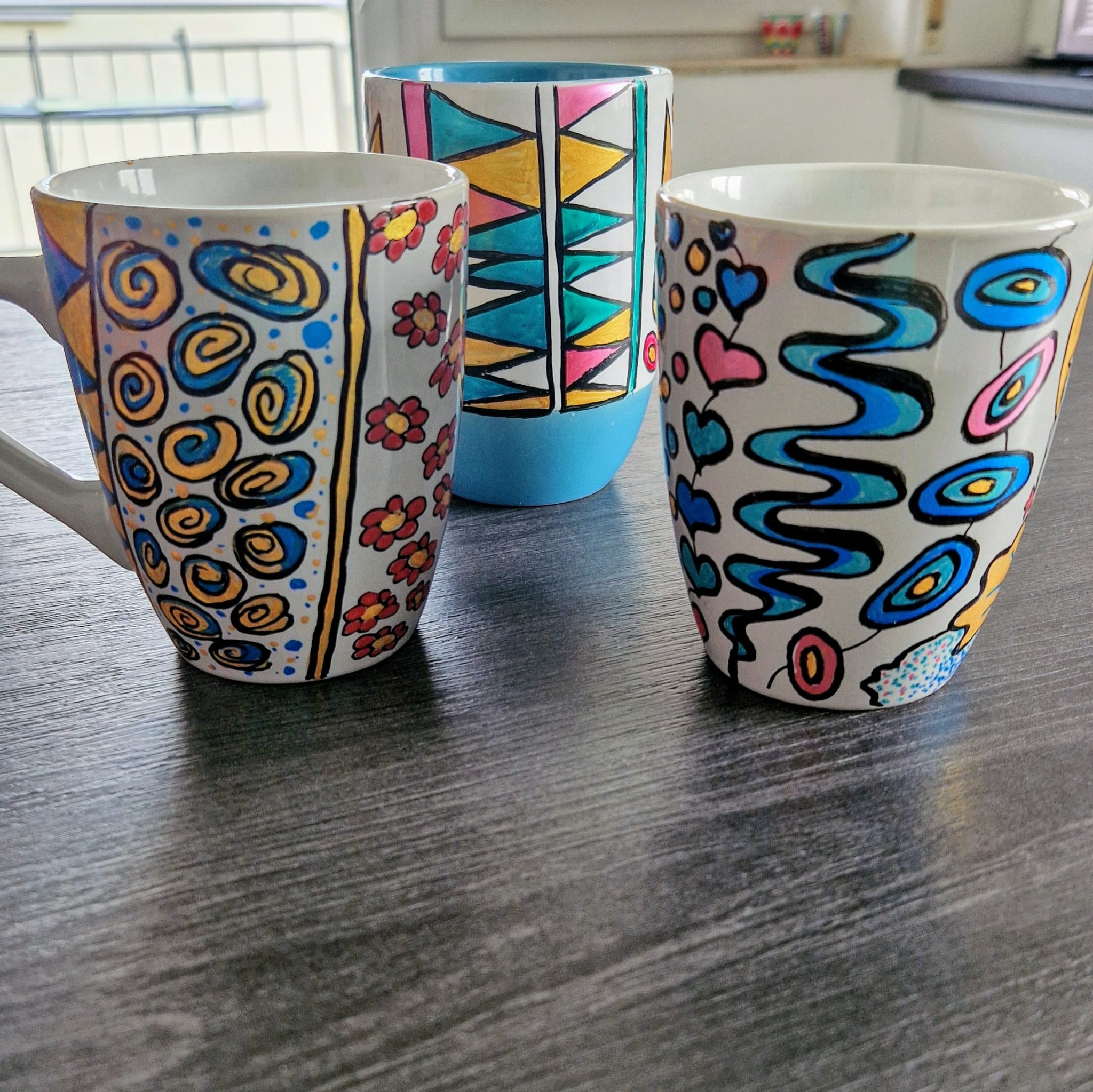 Drei Tassen bemalt mit verschiedenen Motiven