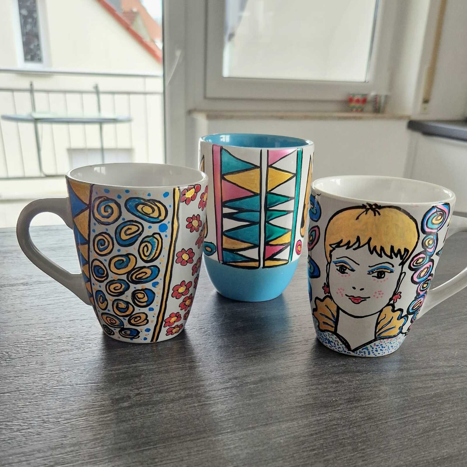 Drei Tassen bemalt mit Mustern und Gesicht